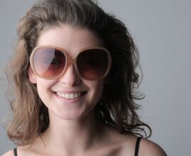 Femme souriante portant de grandes lunettes de soleil rondes