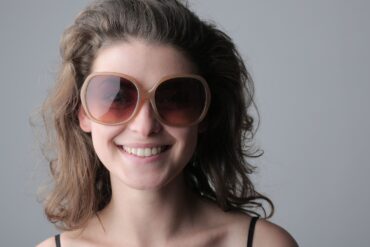 Femme souriante portant de grandes lunettes de soleil rondes
