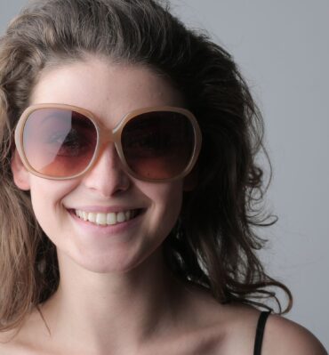 Femme souriante portant de grandes lunettes de soleil rondes