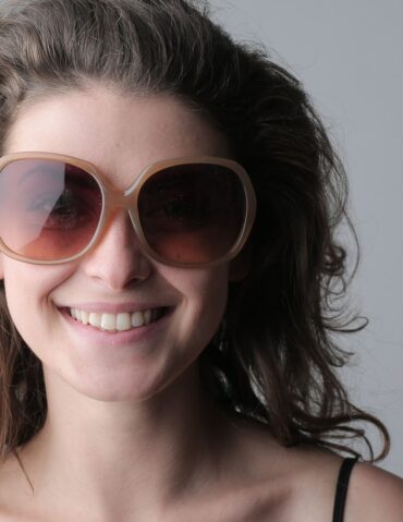 Femme souriante portant de grandes lunettes de soleil rondes