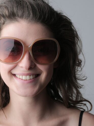 Femme souriante portant de grandes lunettes de soleil rondes