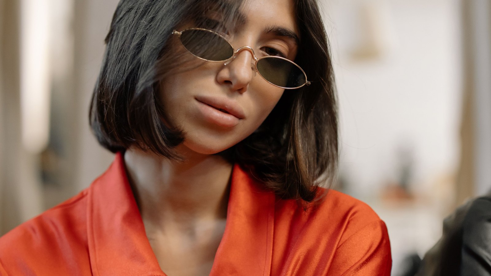 Femme portant de petites lunettes de soleil ovales à monture fine