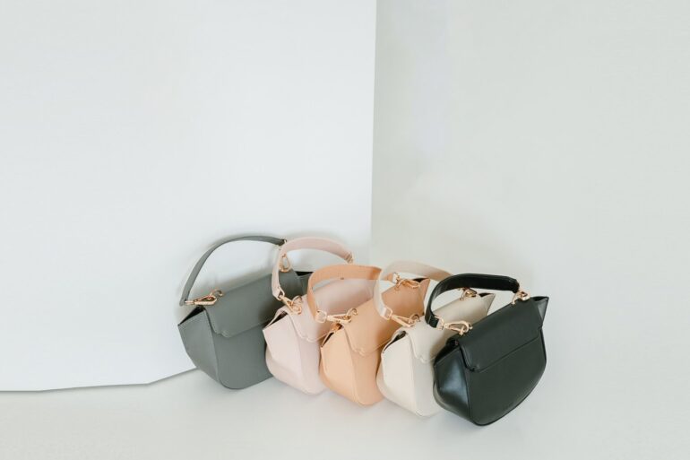 Trois mini sacs alignés, gris, beige et noir, sur fond clair
