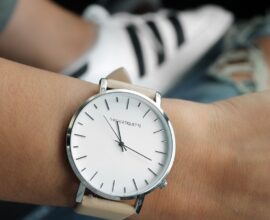 Montre à cadran blanc et bracelet clair portée au poignet