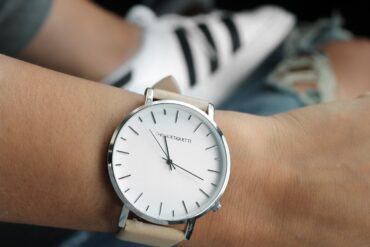 Montre à cadran blanc et bracelet clair portée au poignet