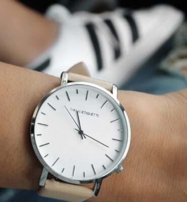 Montre à cadran blanc et bracelet clair portée au poignet
