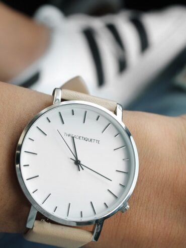 Montre à cadran blanc et bracelet clair portée au poignet