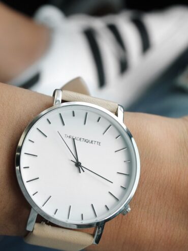 Montre à cadran blanc et bracelet clair portée au poignet