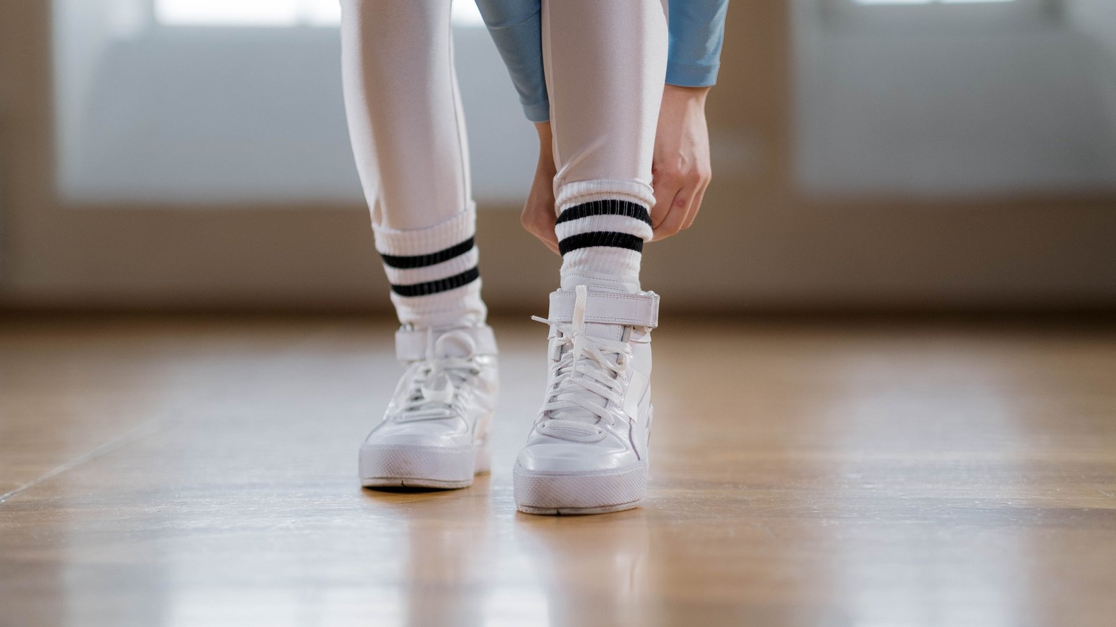 Baskets blanches montantes portées avec des chaussettes à rayures