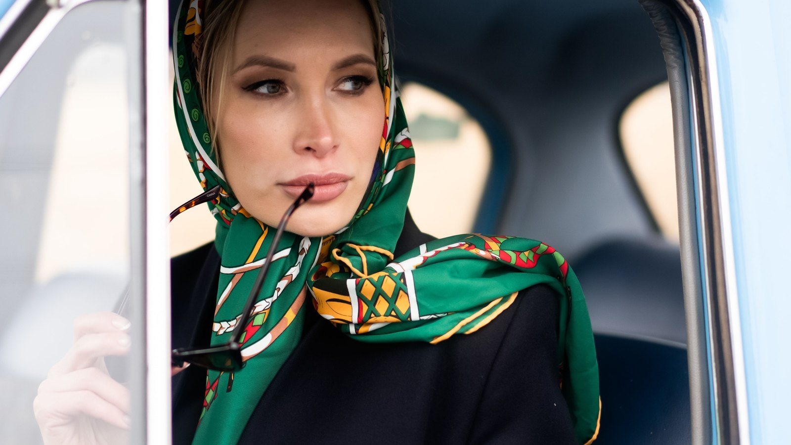 Foulard de soie vert à imprimé porté sur la tête